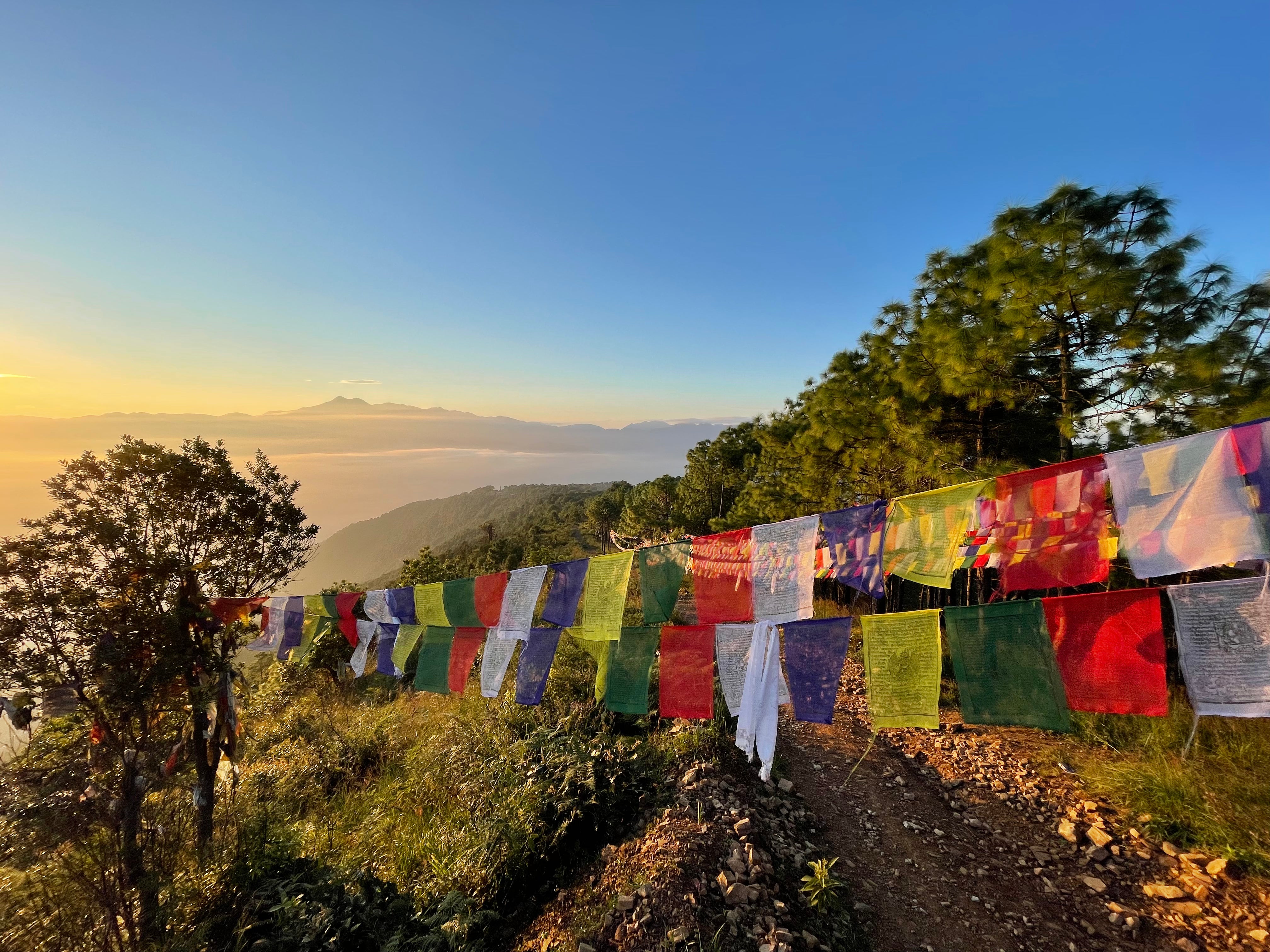 Prayer flags over a hiking track in Nepal during an epic sunrise