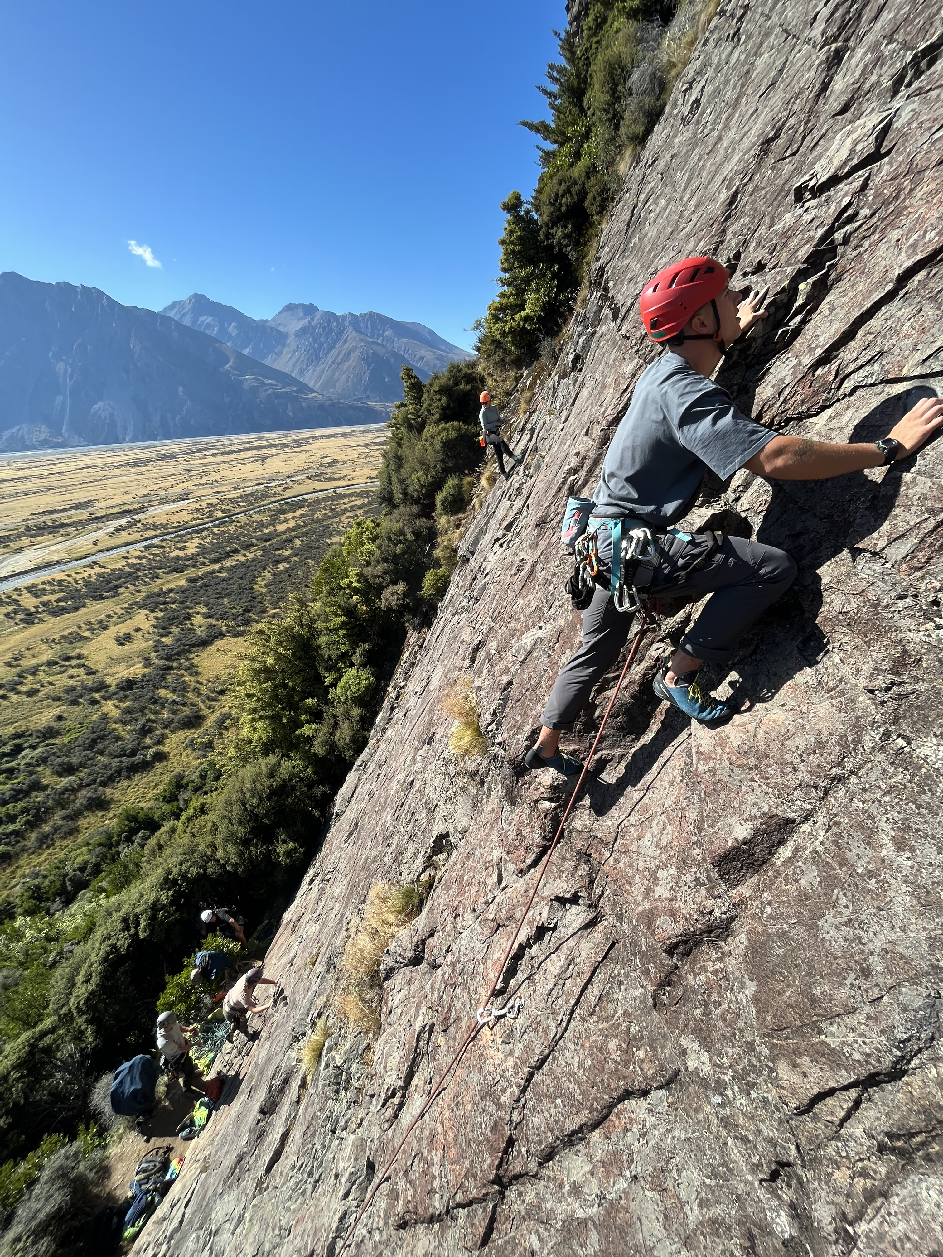 Student rock climbing a smooth crag in Mt Aspiring National Park New Zealand